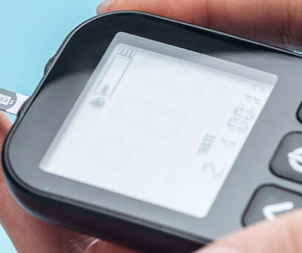 A picture of a hand holding a diabetes monitoring device.