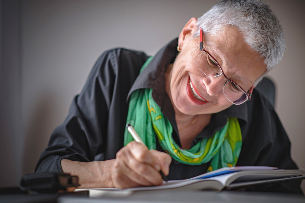A picture of a woman enjoying writing in a notebook.