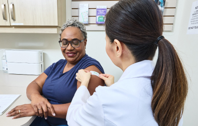 A doctor applying a bandage to a woman's hand.
