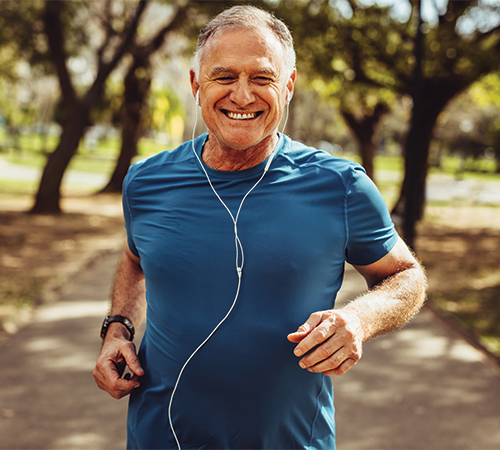Man jogging outdoors in athletic wear.