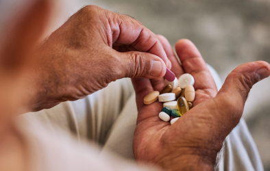 A person holding multiple medicines in their hands.