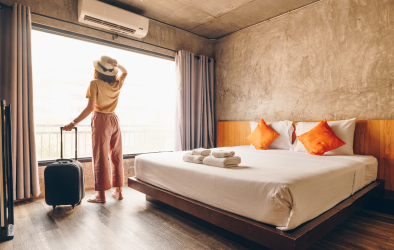 A woman standing in front of a window, holding a bag in her hand.