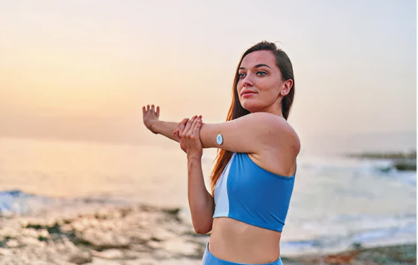 A woman stretching her arm during a workout.