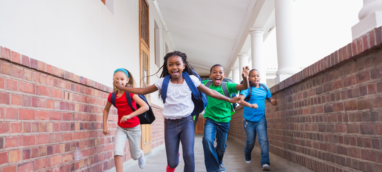 Four children racing on a school field